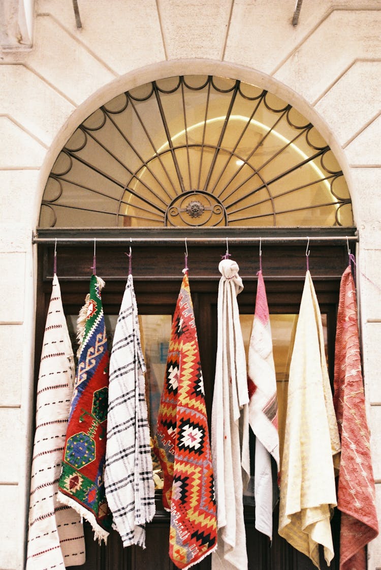 Assorted Rugs Hanging In An Arched Doorway 