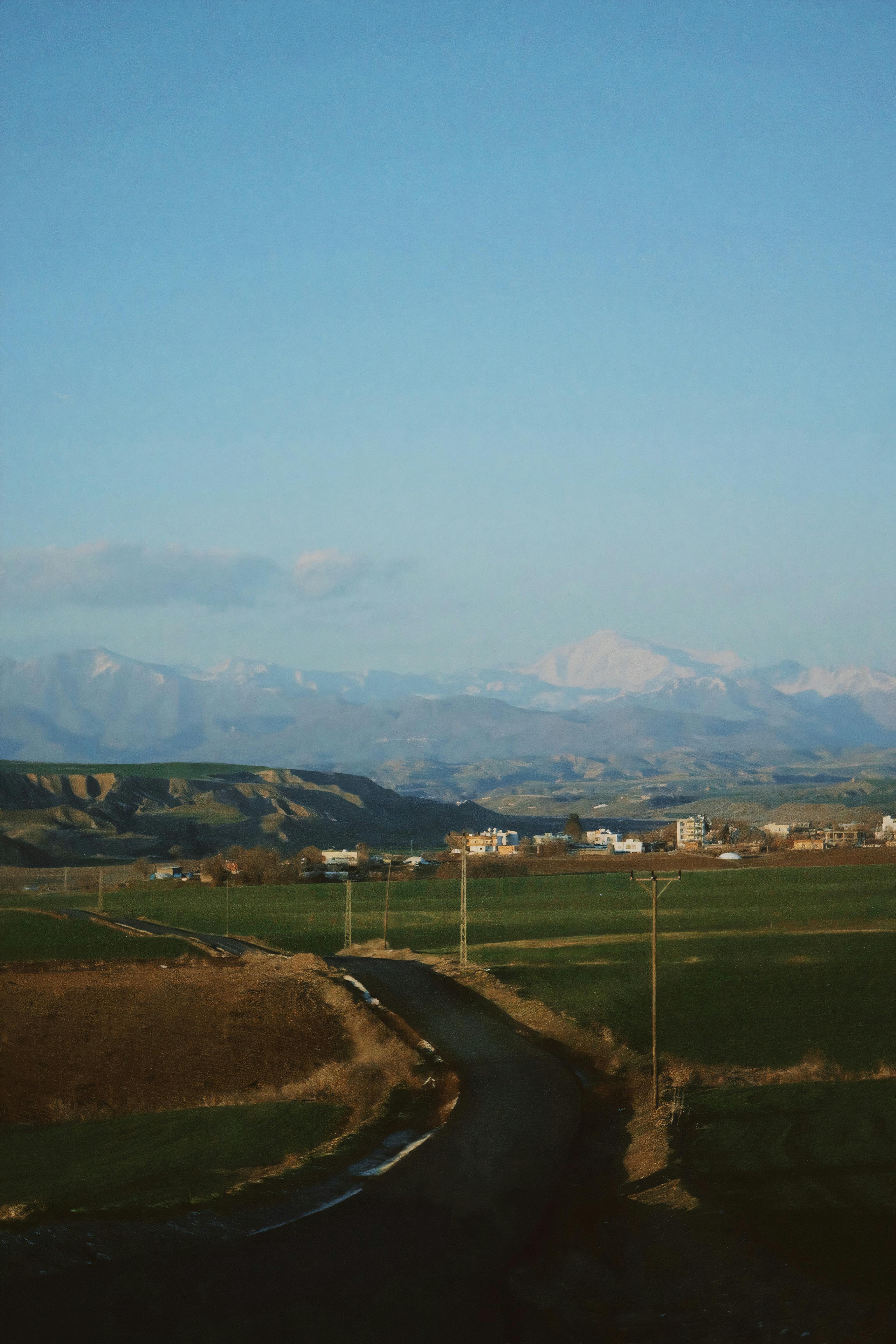 A breathtaking aerial view of the rural countryside with fields, road, and distant mountains.