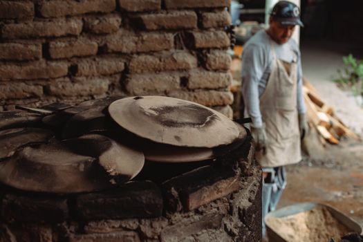Rustic pottery workshop featuring clay pots being crafted by a skilled artisan.