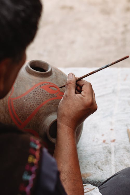 A Person Painting on the Ceramic Pot