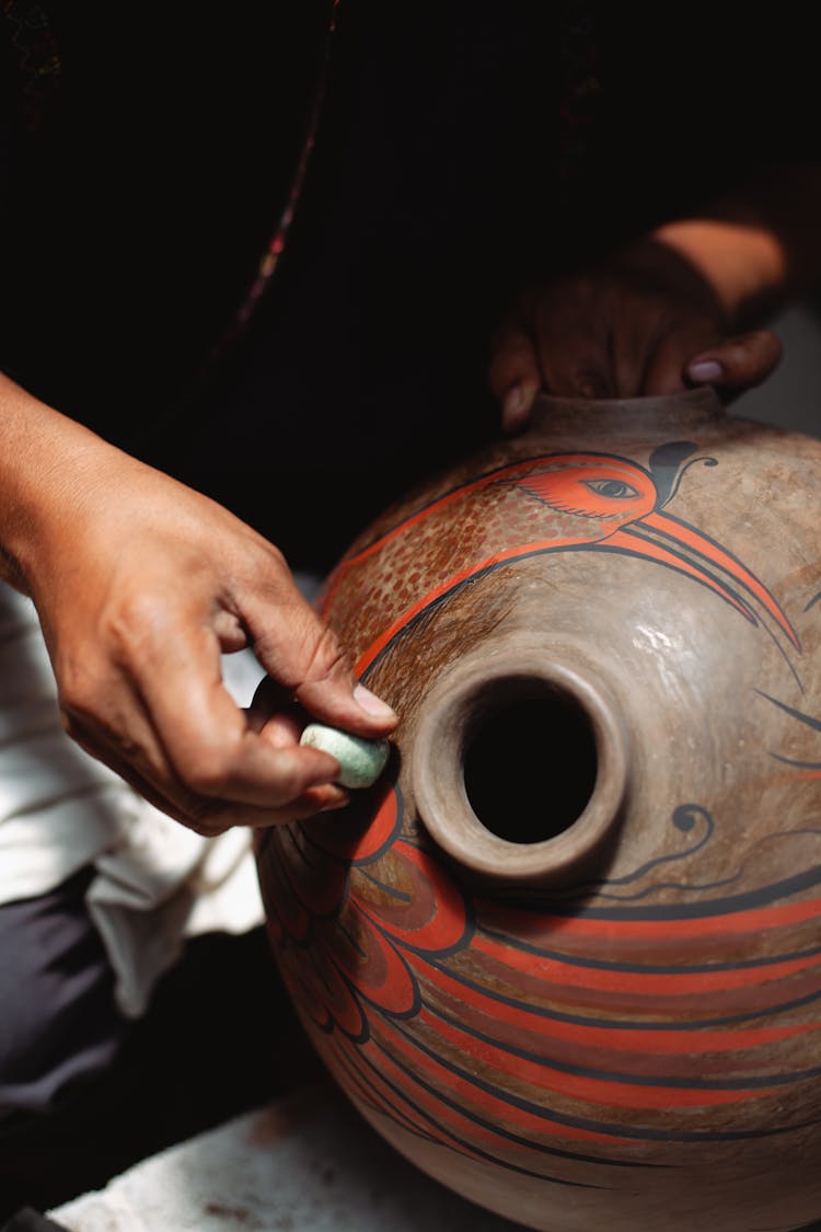 Hands Of A Person Holding A Clay Jar