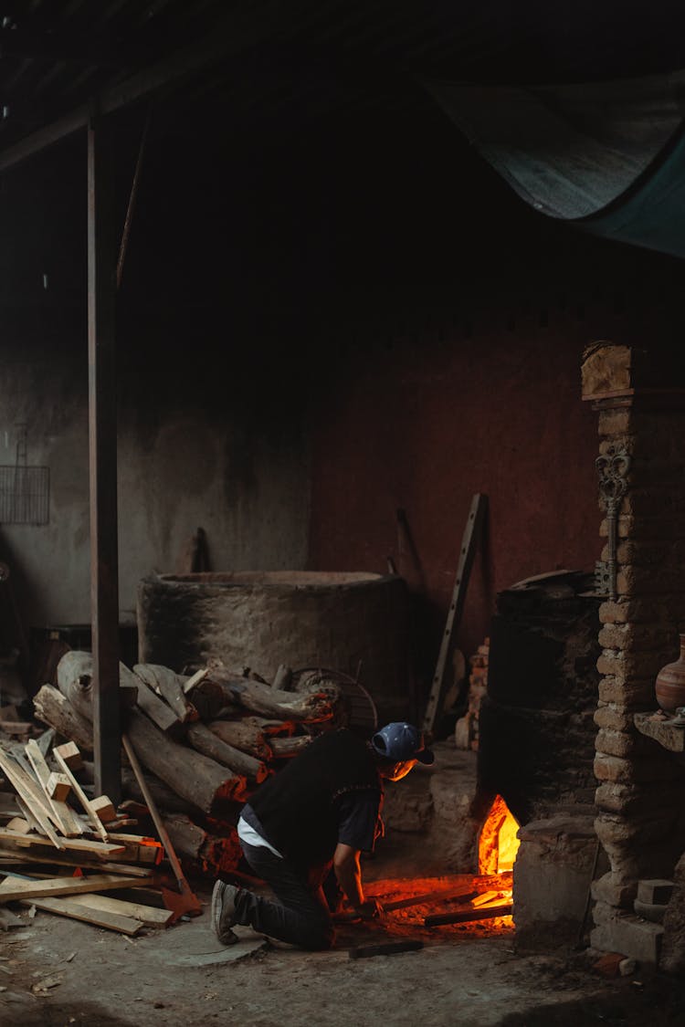 Man Putting Logs In A Fireplace