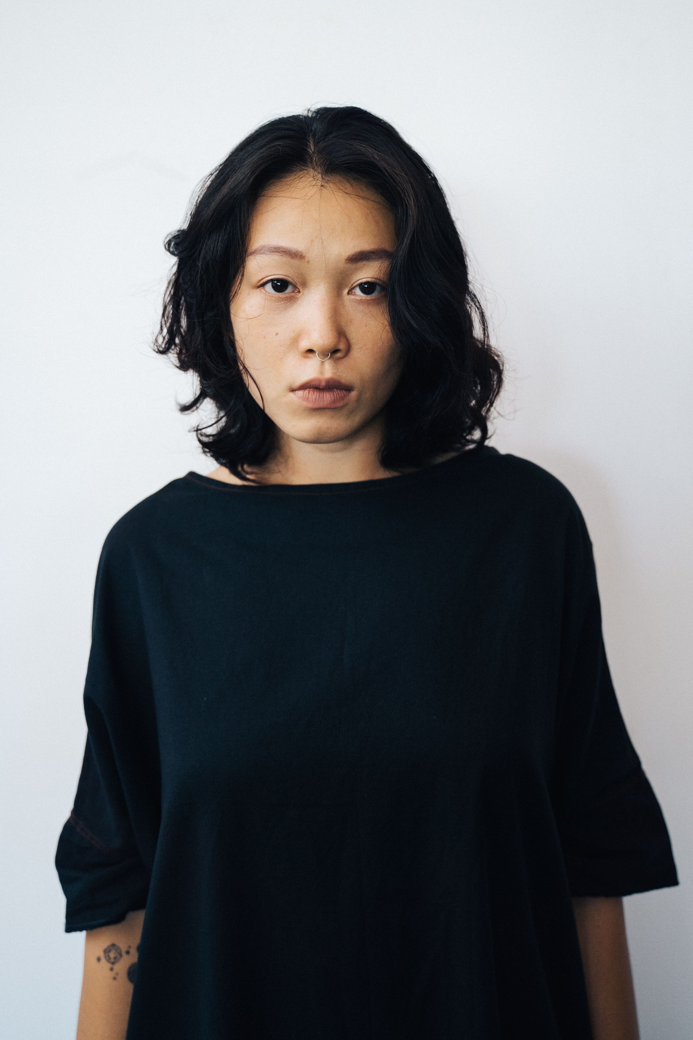 Close-up portrait of a woman with a thoughtful expression against a white background.