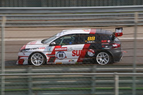 Free Action shot of a fast race car speeding on a Taiwan racetrack, blurred background conveying speed. Stock Photo