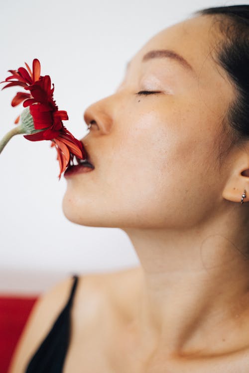 Woman Smelling a Red Flower