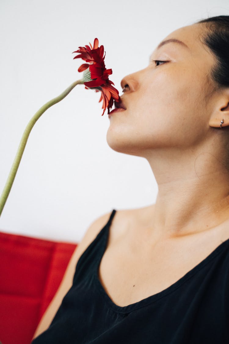 Woman In Black Tank Top Smelling A Flower