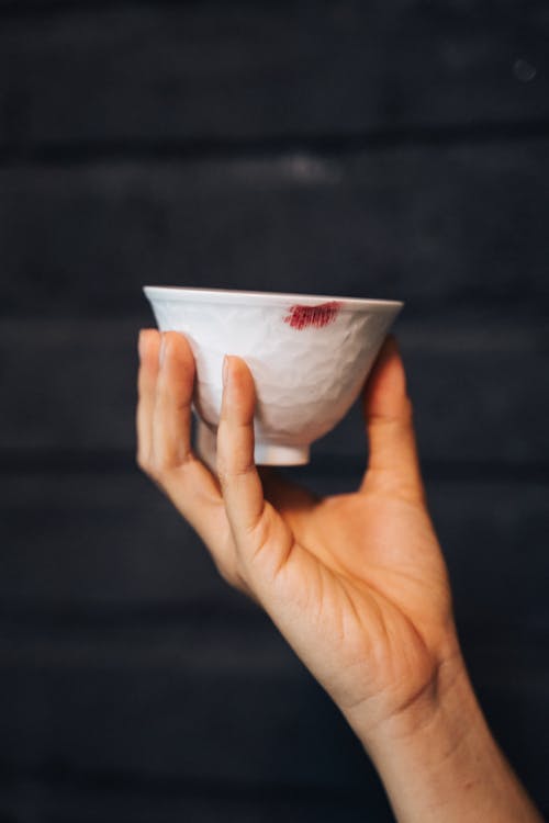 Person Holding a Small White Bowl