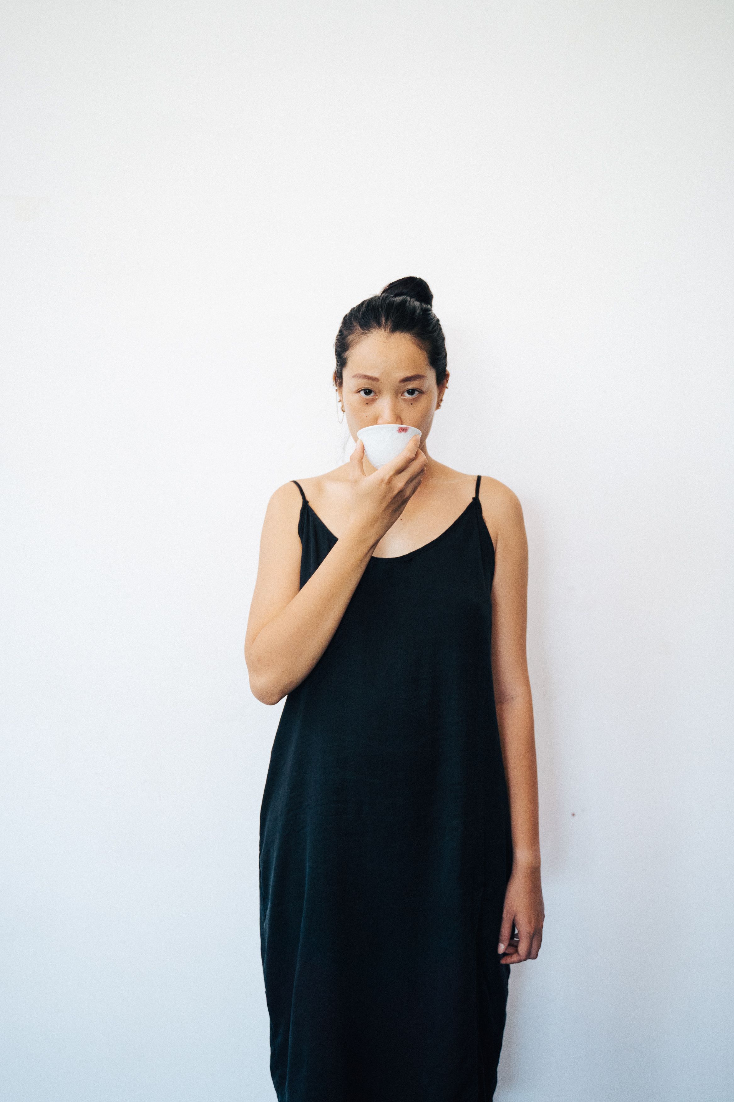 Woman in Black Dress Holding a Cup · Free Stock Photo