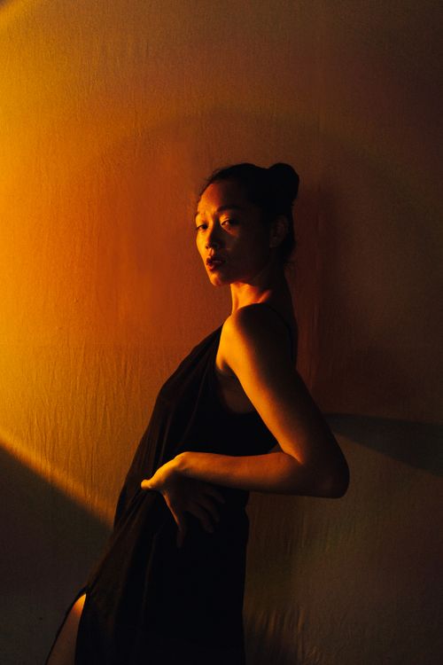 Woman in Black Dress Posing while Leaning on a Wall · Free Stock Photo