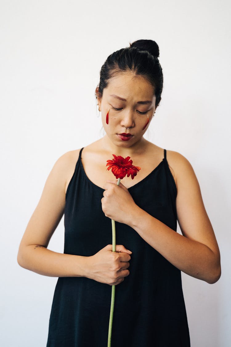 A Sad Woman Holding A Red Flower