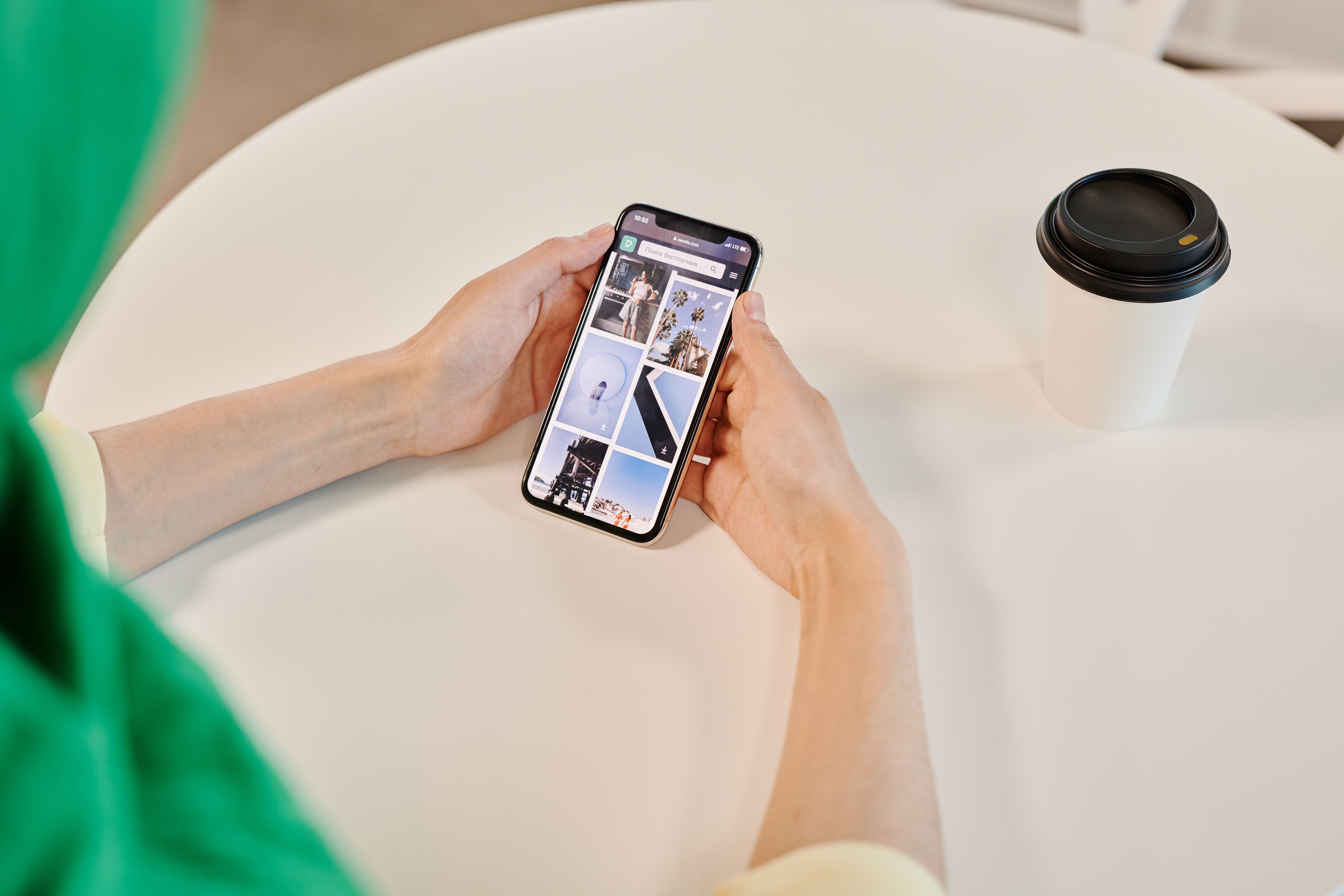 schermo di telefono che mostra un biglietto aereo PDF con un caffè su un tavolo in aeroporto