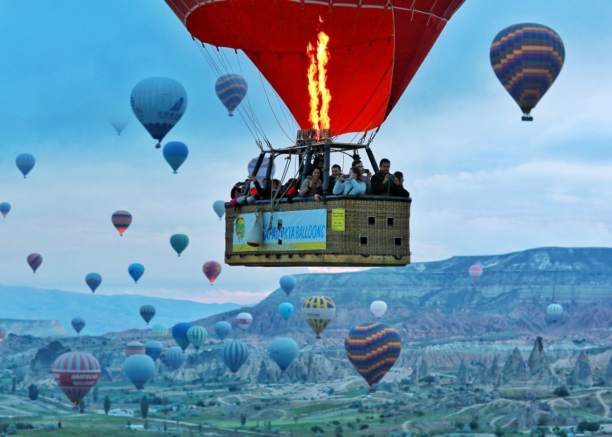 Hot air balloons soar over Cappadocia, Turkey's stunning landscape at sunrise.