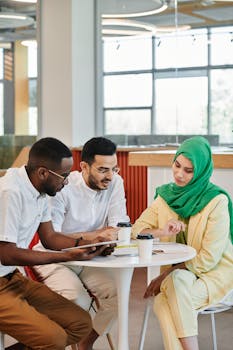 A multicultural group discusses ideas over coffee in a modern cafe setting.