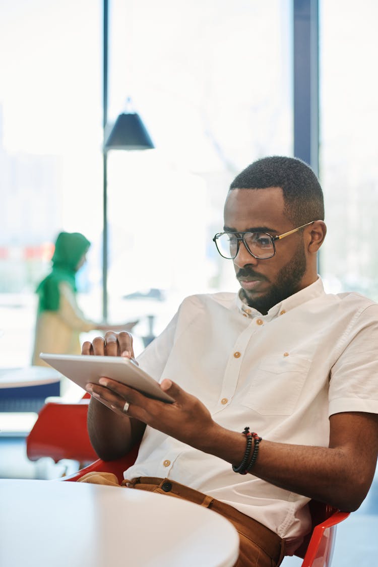 A Man In White Dress Shirt Using A Digital Tablet