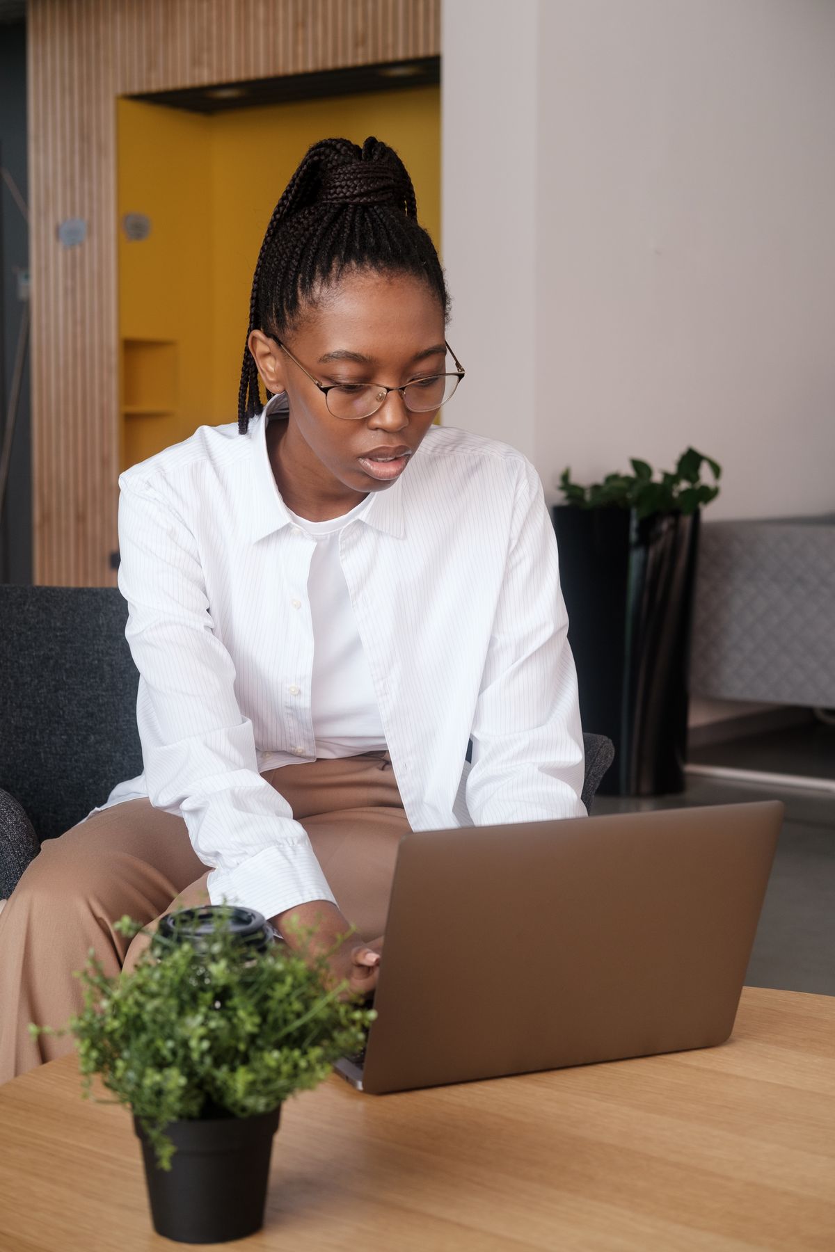 Black female professional working on a laptop in a modern office