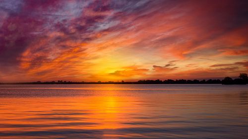 Free Stunning sunset with vibrant colors reflecting on the ocean, capturing a tranquil seascape view. Stock Photo