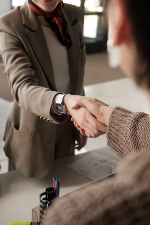 Free Two professionals shaking hands in an office, signifying a successful business agreement. Stock Photo Free Two professionals shaking hands in an office, signifying a successful business agreement. Stock Photo