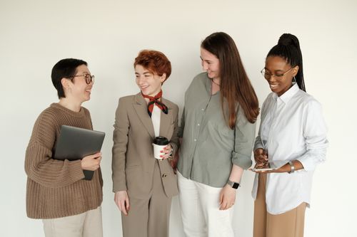 Free A diverse group of women coworkers smiling together in a professional office setting. Stock Photo