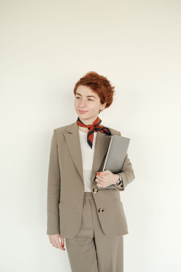 Woman in charcoal suit with silk scarf
