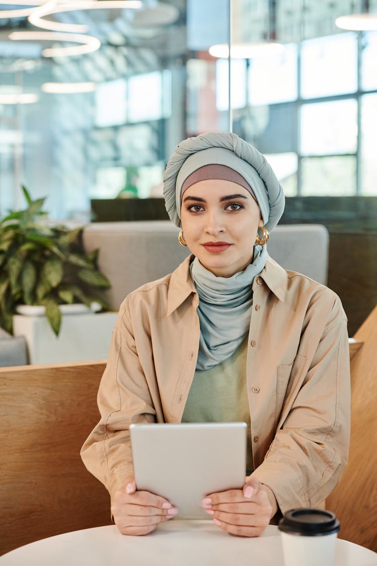 Woman Sitting With Tablet By Table