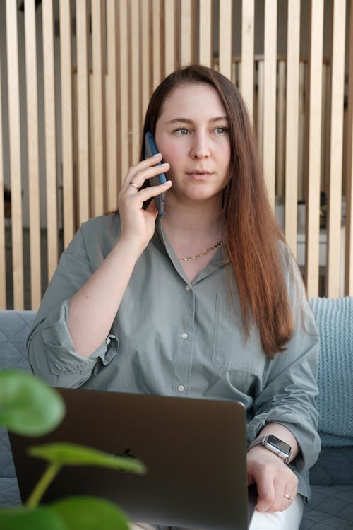 Free Woman Sitting on Sofa While on a Phone Call Stock Photo