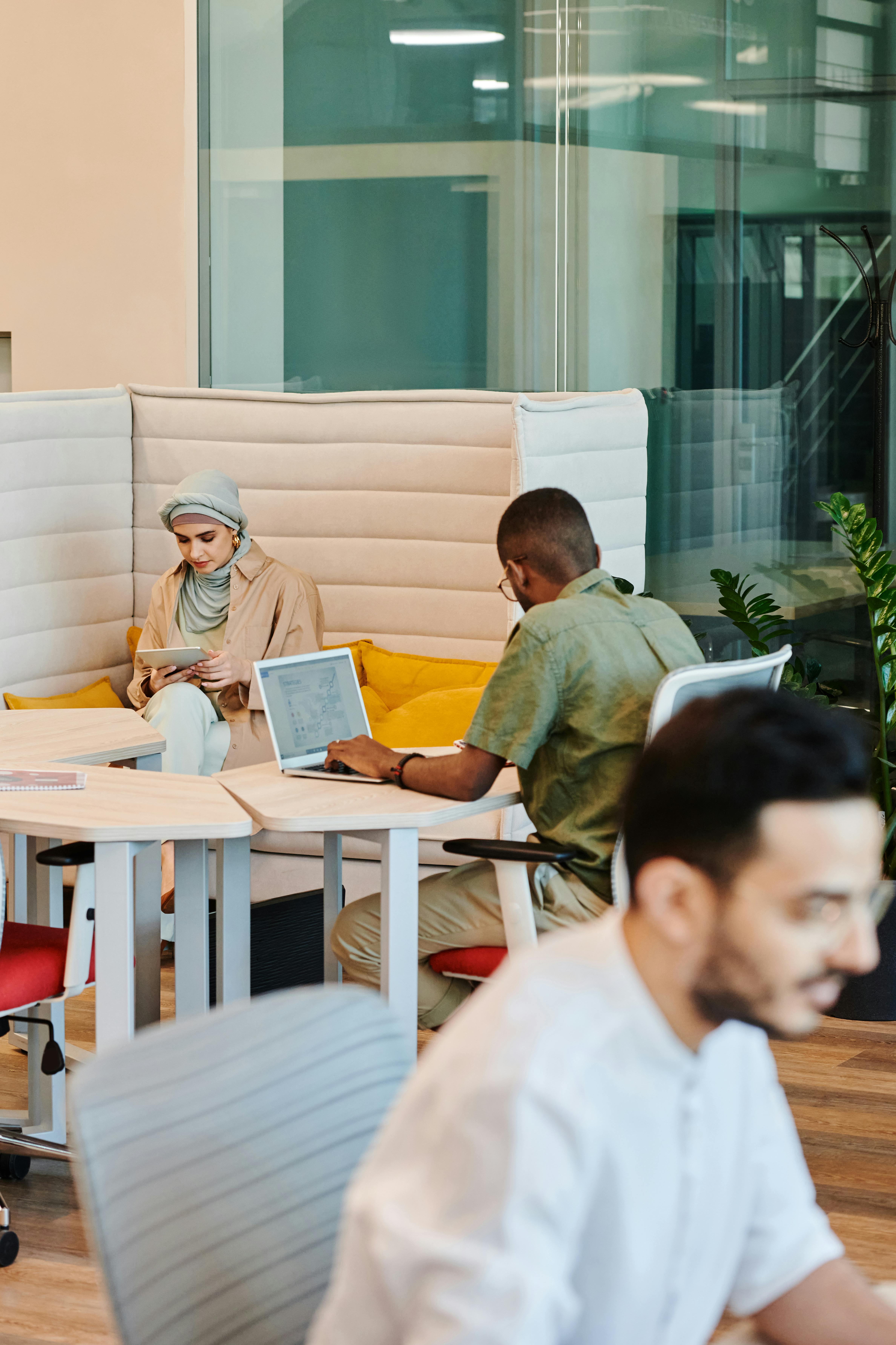 A diverse group of professionals working with technology in a modern office space, fostering collaboration and productivity.