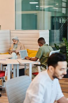 A diverse group of professionals working with technology in a modern office space, fostering collaboration and productivity.