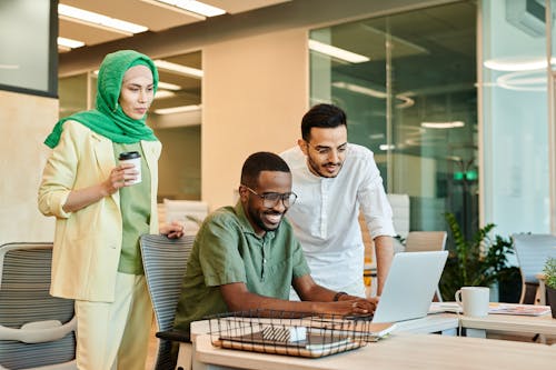 Free Men and Woman Looking at the Screen of a Laptop Stock Photo