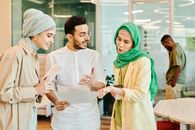 Woman in Green Hijab Holding White Paper