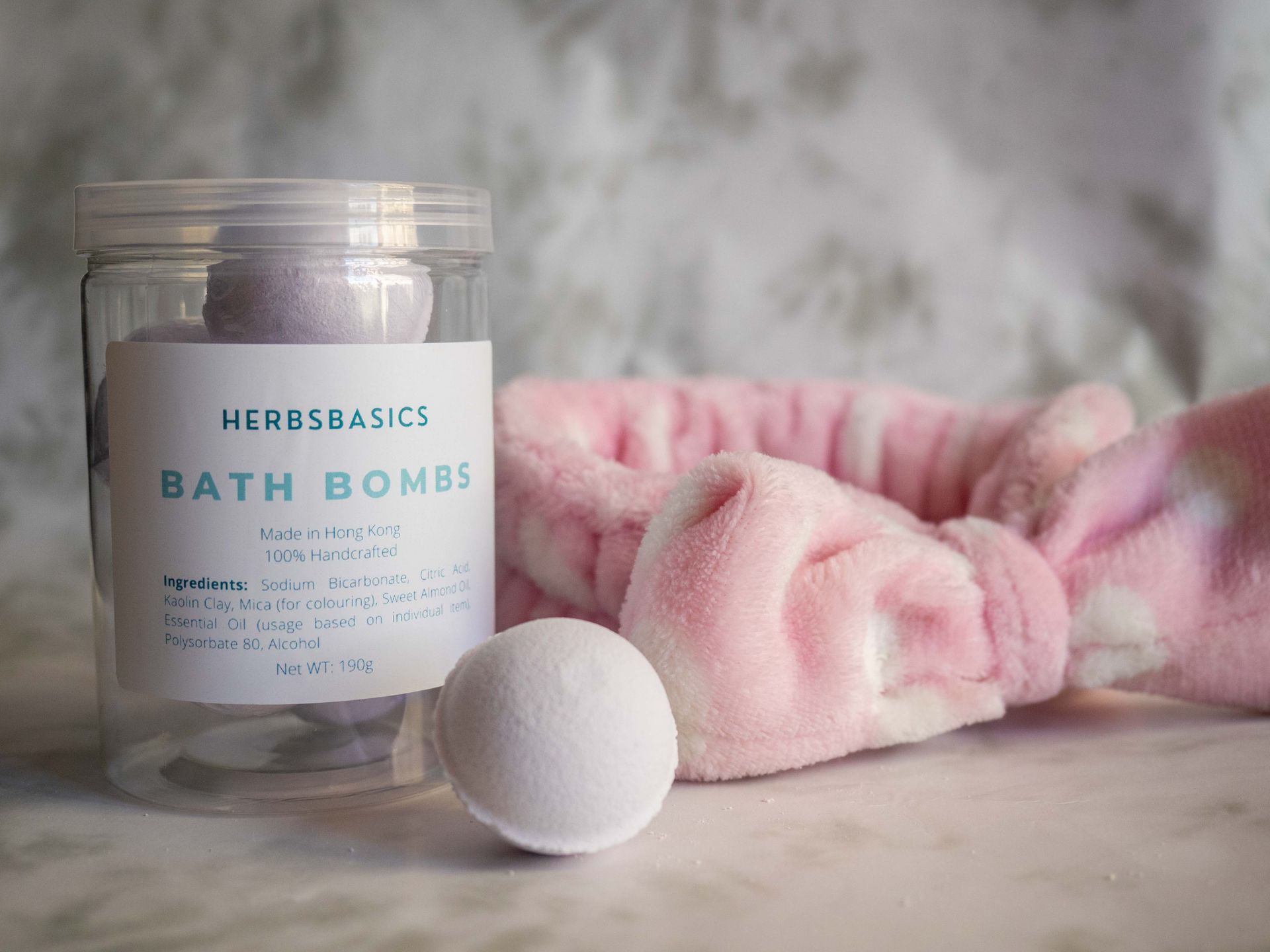 Luxurious bath bombs and headband on a marble surface for a relaxing bath experience.