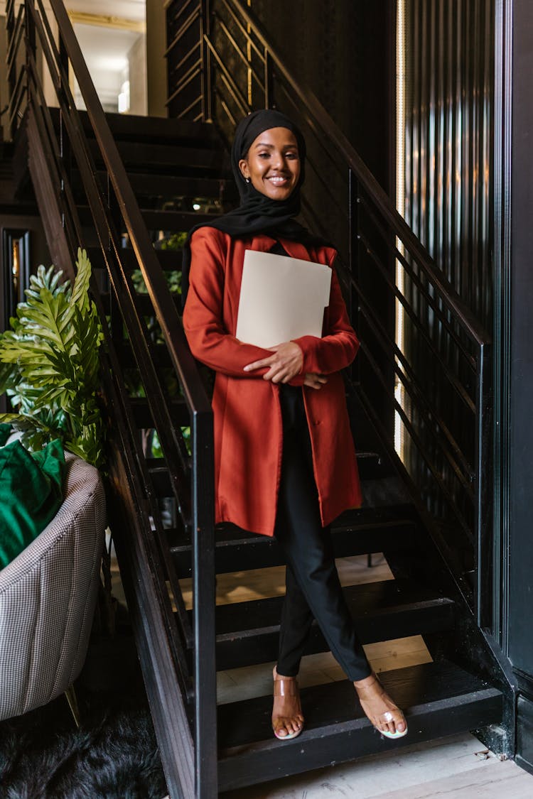 Woman Holding A Folder While Standing On Stairs