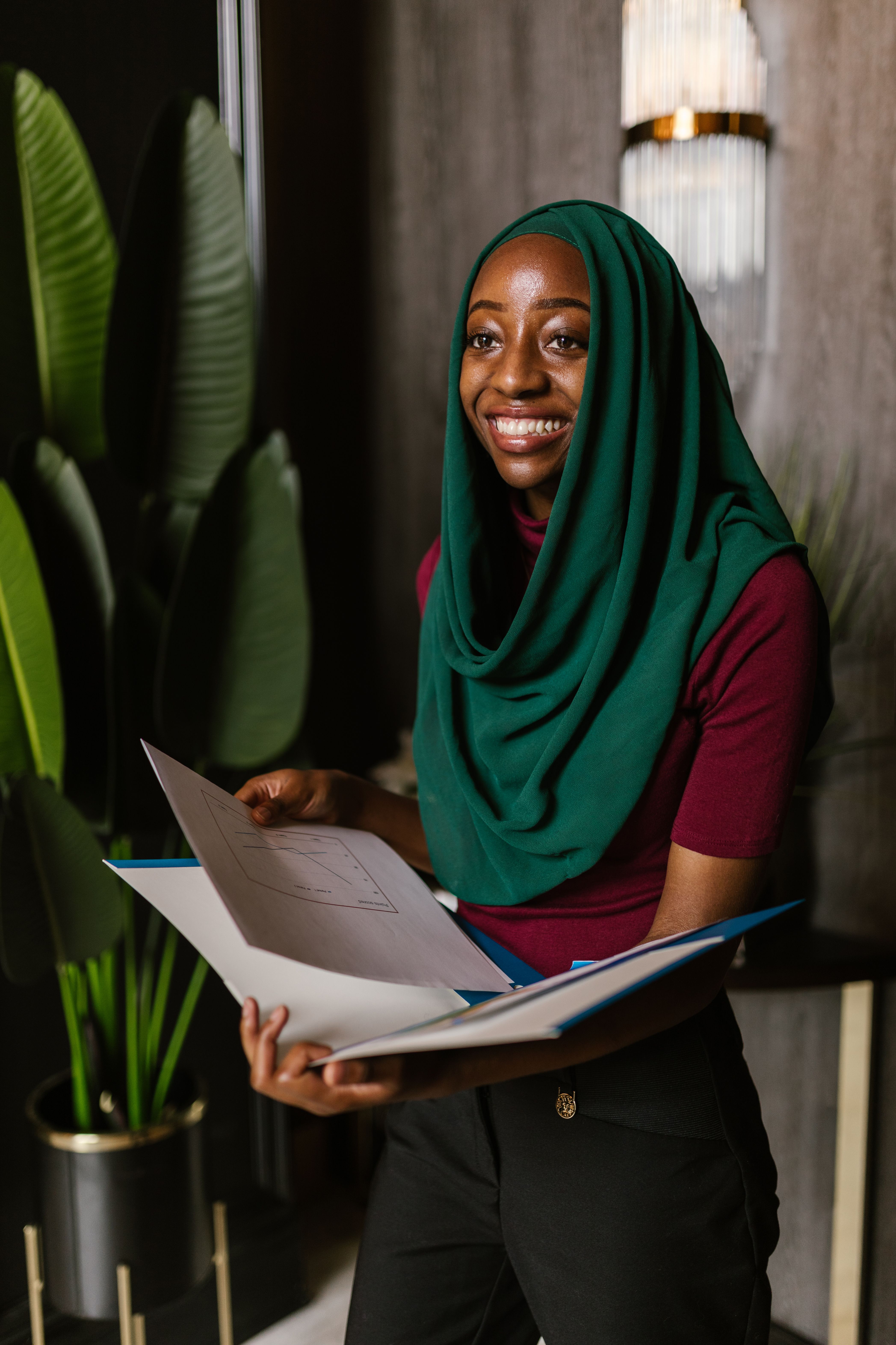 Black Muslim lady in hijab talking on phone on couch · Free Stock Photo