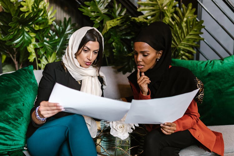 Women Wearing Headscarf Sitting On A Couch While Having A Conversation