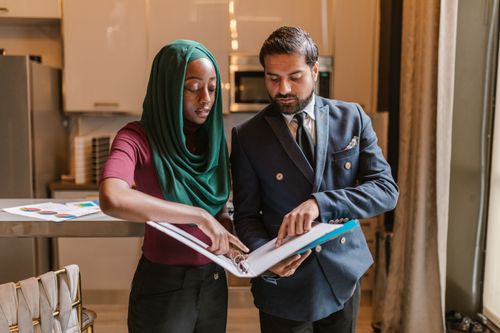 Free Diverse business professionals discussing documents in a modern office setting. Stock Photo