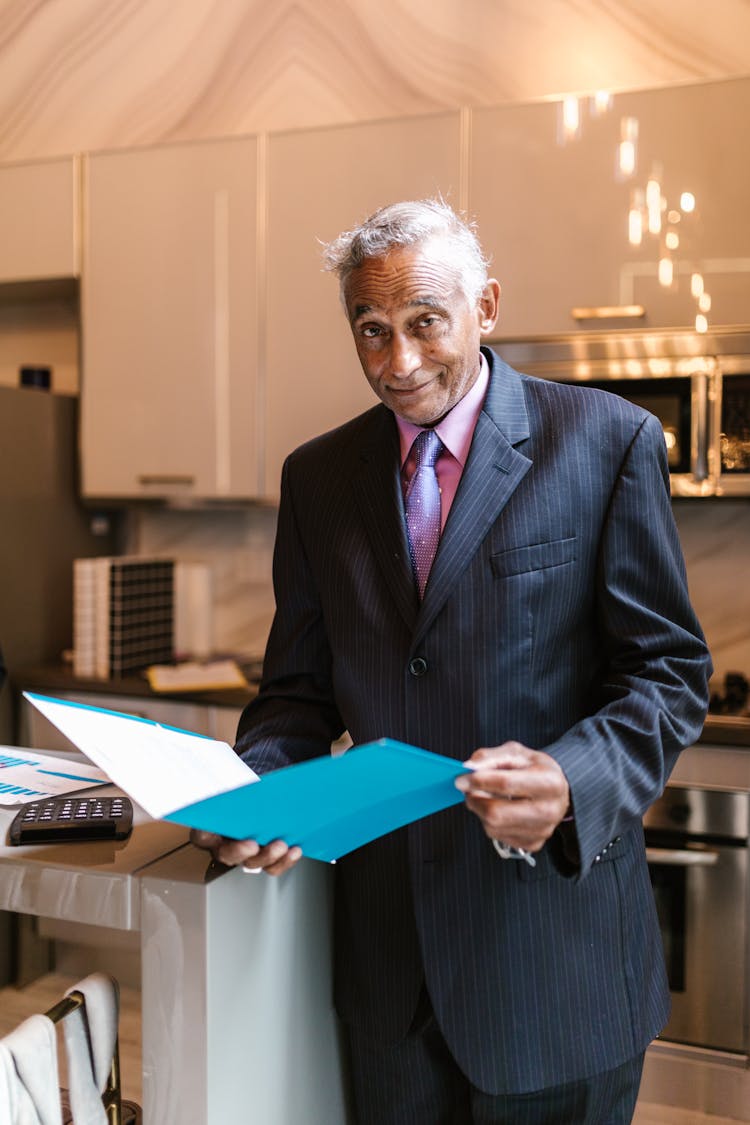 Elderly Man Holding A Blue Folder