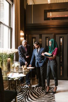A diverse group of business professionals in a stylish office discussing a project.
