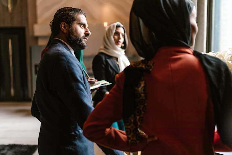 Elegant Man Listening Women At Business Meeting