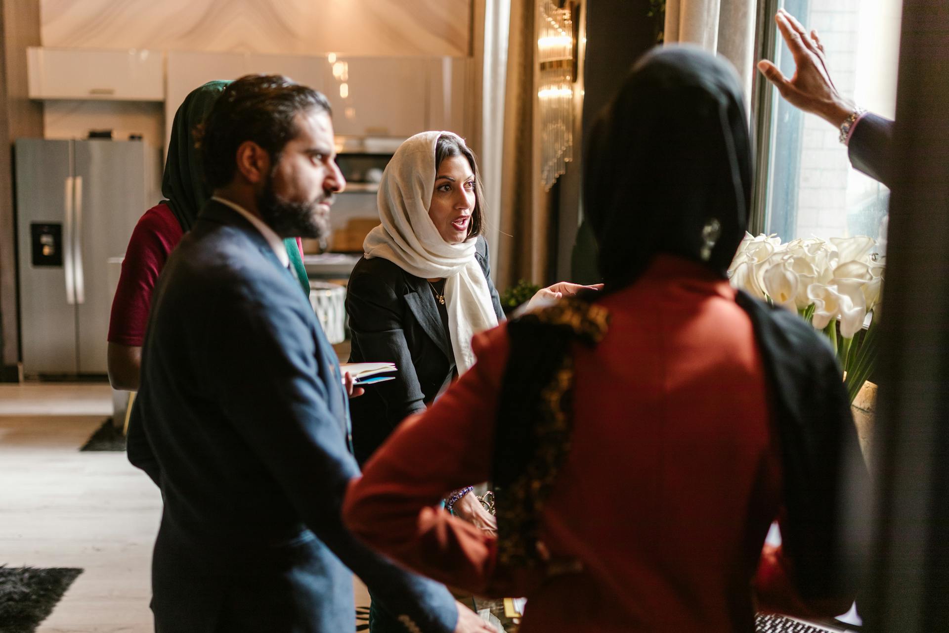 A diverse group in business attire having a meeting and discussing ideas indoors.