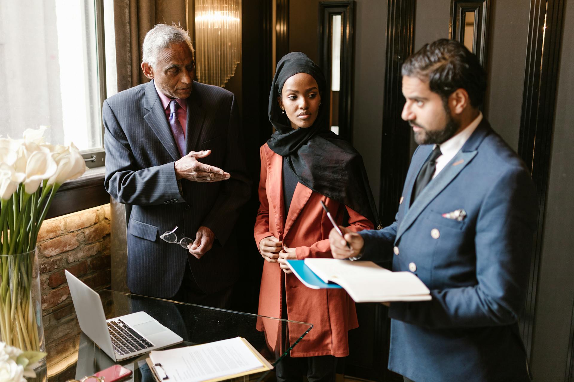 Group of professionals in business attire discussing strategy indoors.