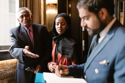 A diverse group engages in a professional meeting. Strong focus on collaboration.