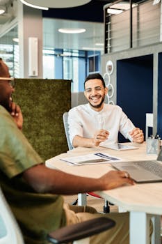 Two young professionals discussing business ideas in a modern office setting.