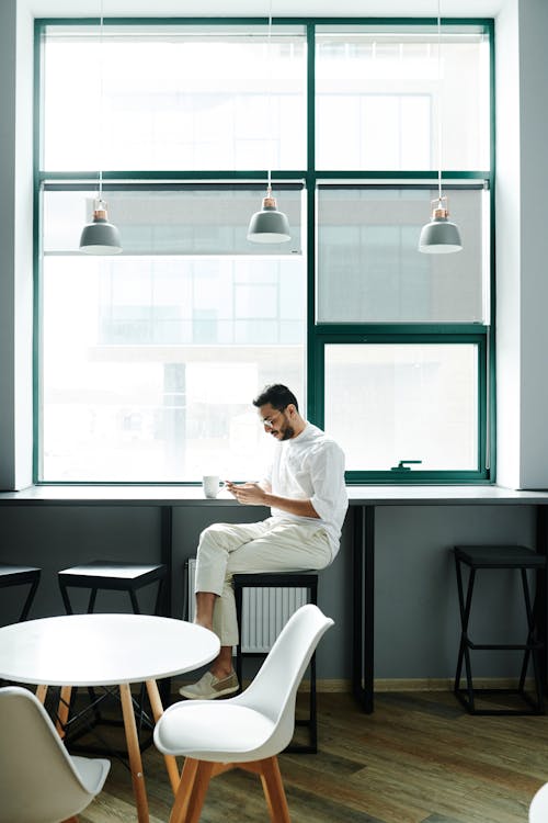 Man Sitting near the Glass Window 