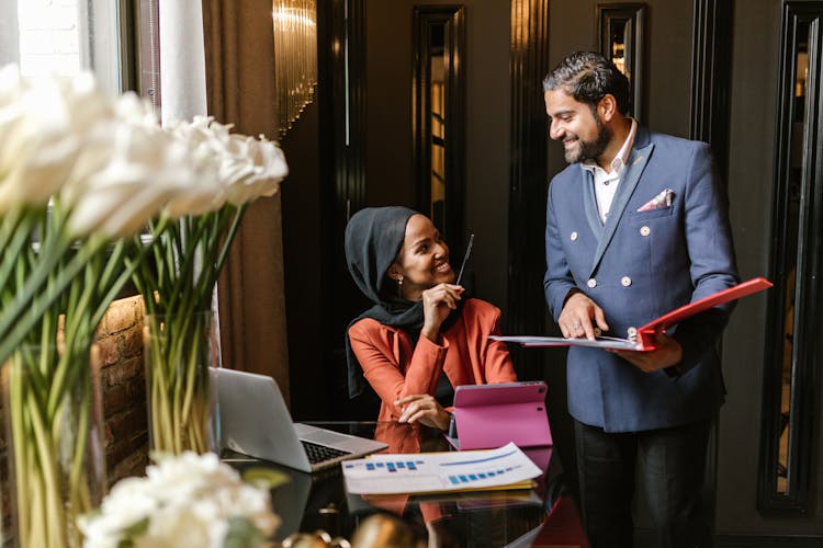 Elegant Man And Woman Holding Documents And Smiling 