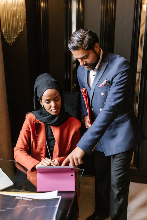 Business Partners Looking at the Screen of a Tablet Device while Having a Conversation