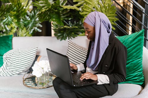 A Woman in Hijab Working with a Laptop