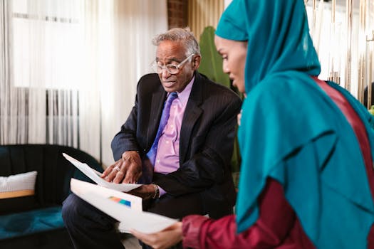 Two professionals in business attire discussing documents in an office setting.