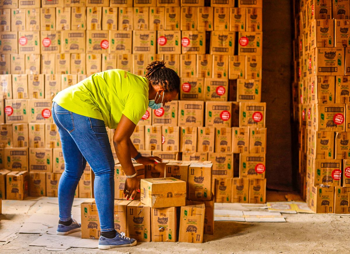 Hardworking employee organizing boxes in a warehouse, promoting efficiency and organization.