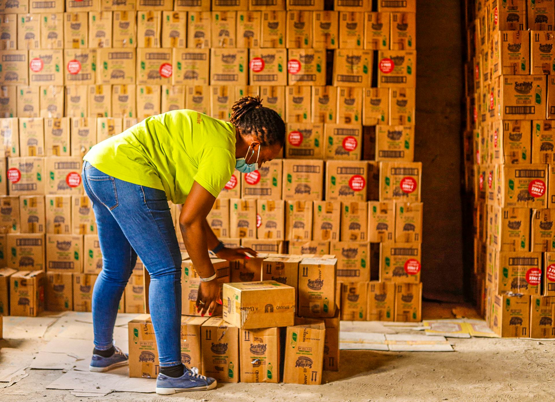 Hardworking employee organizing boxes in a warehouse, promoting efficiency and organization.