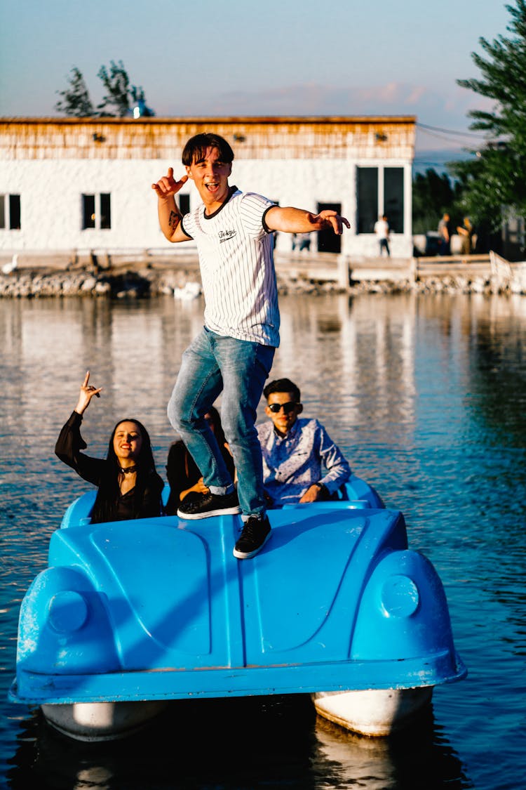 A Group Of Friends Having Fun Riding At The Car Shaped Boat On The Lake