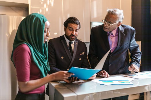 A multicultural business team discussing documents in a contemporary office setting.
